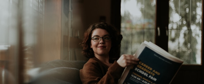 woman in brown coat using black laptop computer