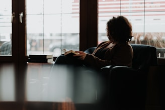 A friendly consultant reviewing a manuscript with an author in a cozy office filled with books and publishing materials.