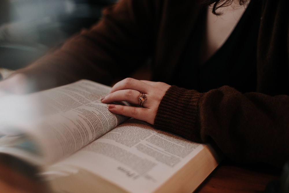 person in brown long sleeve shirt reading book