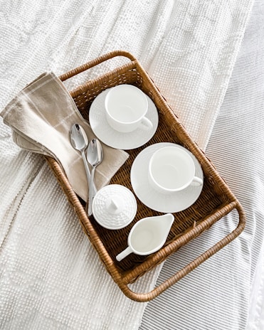 A set of delicate crochet coasters arranged neatly on a wooden table beside a steaming cup of tea.