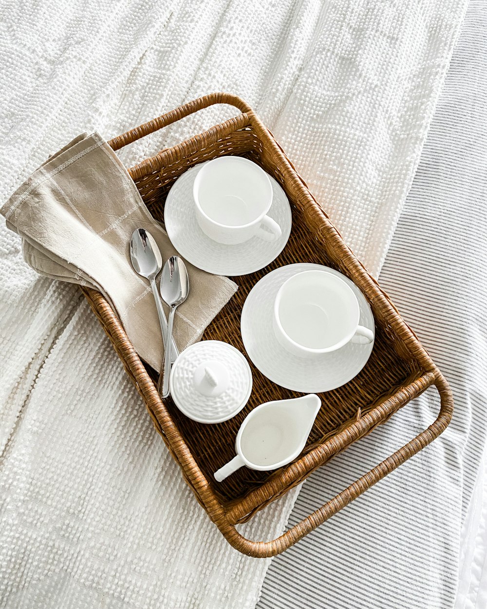 white ceramic cups on brown woven basket