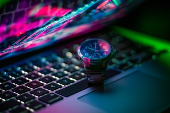 black and silver round analog watch on macbook pro