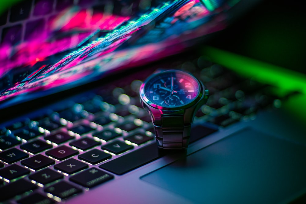 black and silver round analog watch on macbook pro