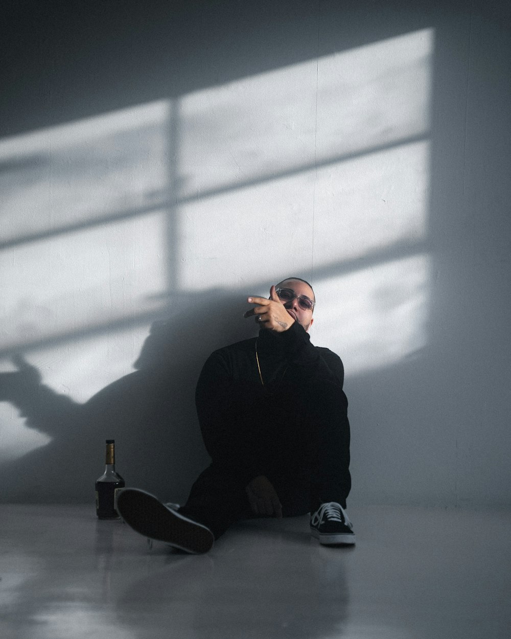 man in black long sleeve shirt and black pants sitting on floor