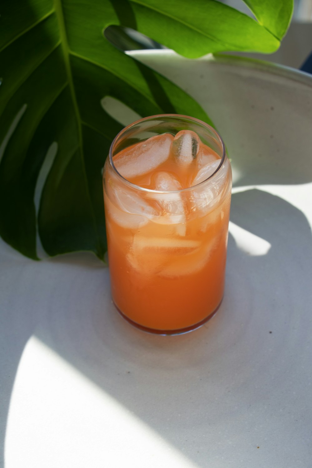 vidro transparente com líquido laranja na placa redonda branca