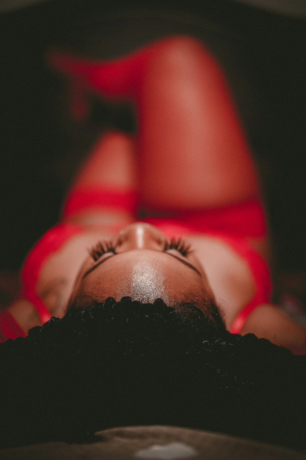 woman in red lipstick lying on black textile