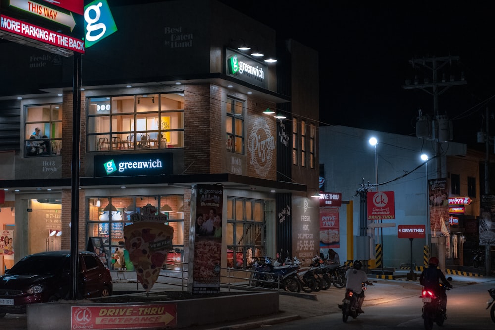 people walking on sidewalk near brown concrete building during nighttime