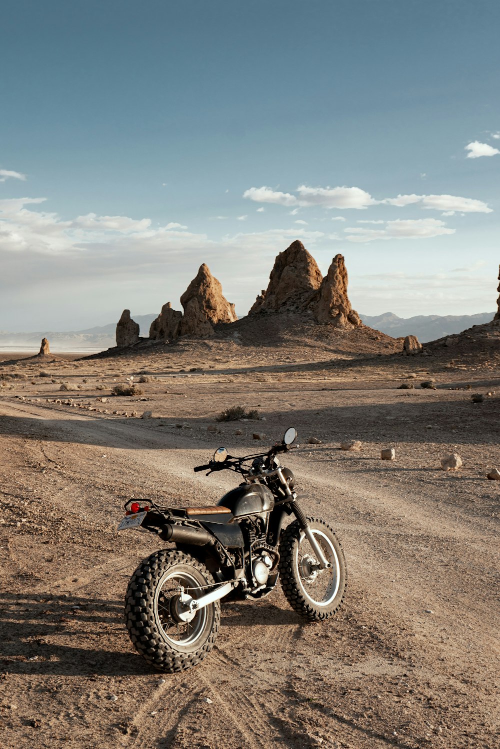 black motorcycle on brown dirt road during daytime