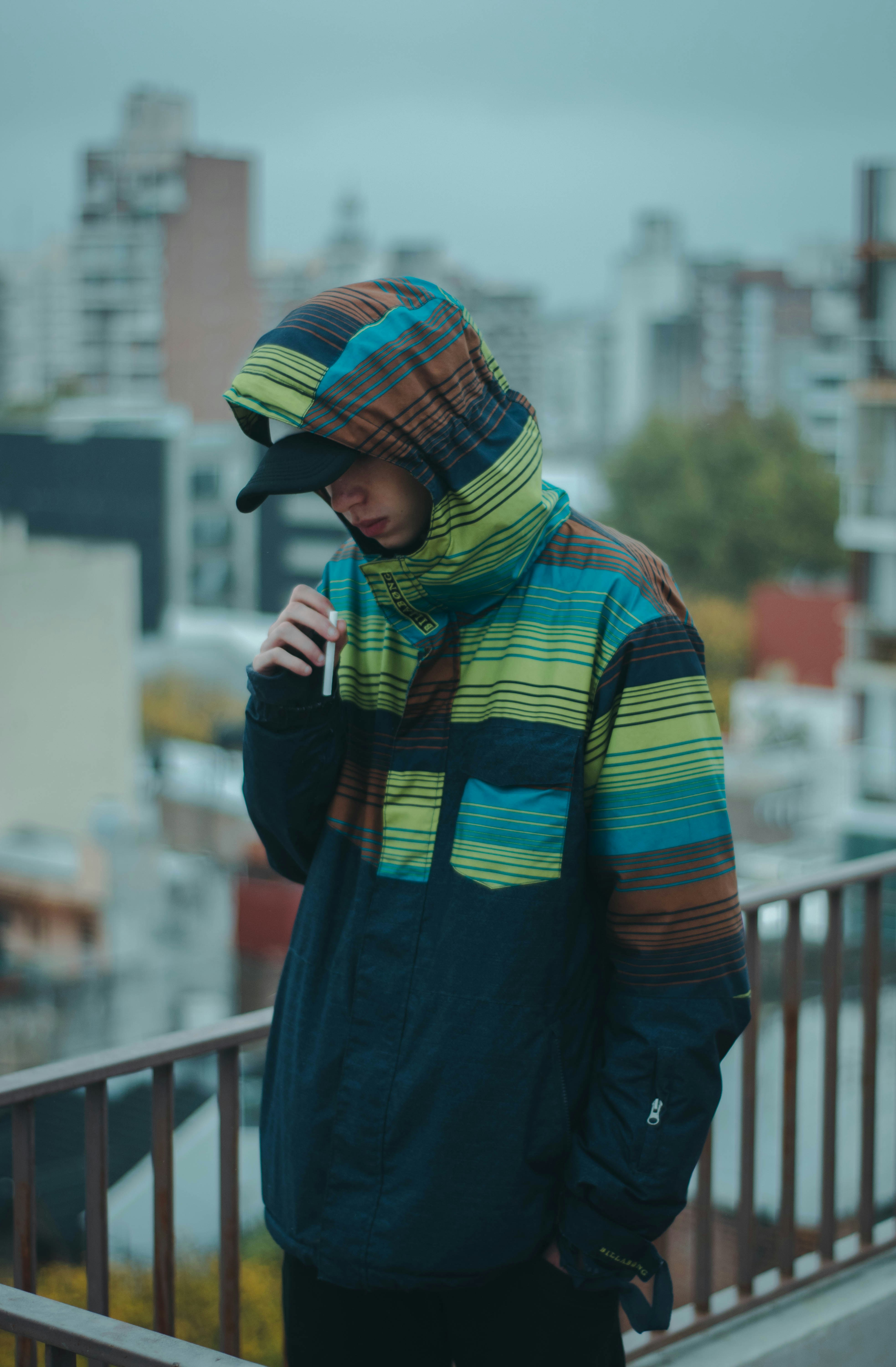woman in green and red hijab standing near railings during daytime