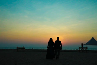 A romantic Latino couple enjoying a sunset walk on a Caribbean beach.