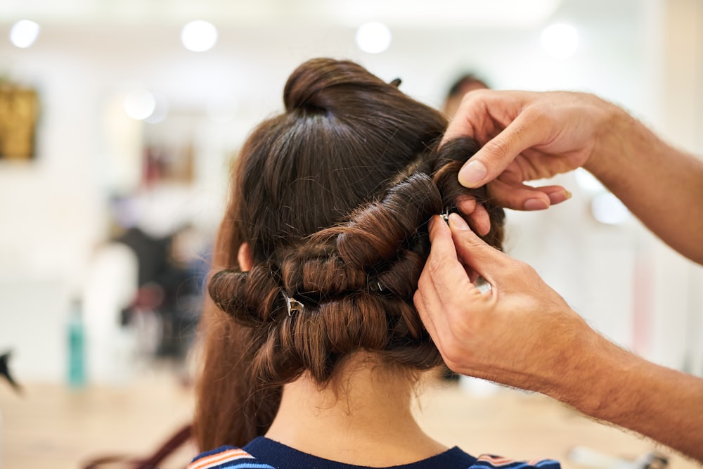 woman in blue shirt holding her hair