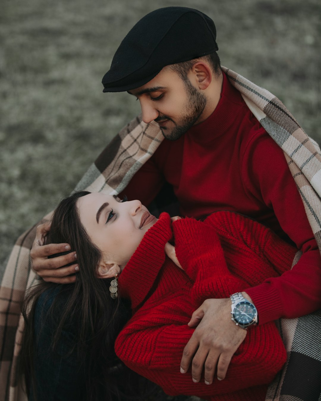 woman in red sweater hugging man in brown and black plaid scarf