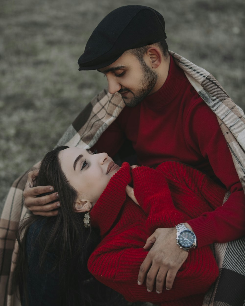 woman in red sweater hugging man in brown and black plaid scarf