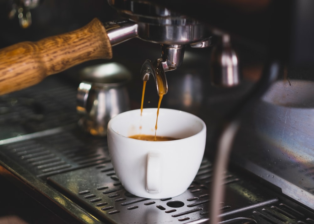 white ceramic cup on silver espresso machine