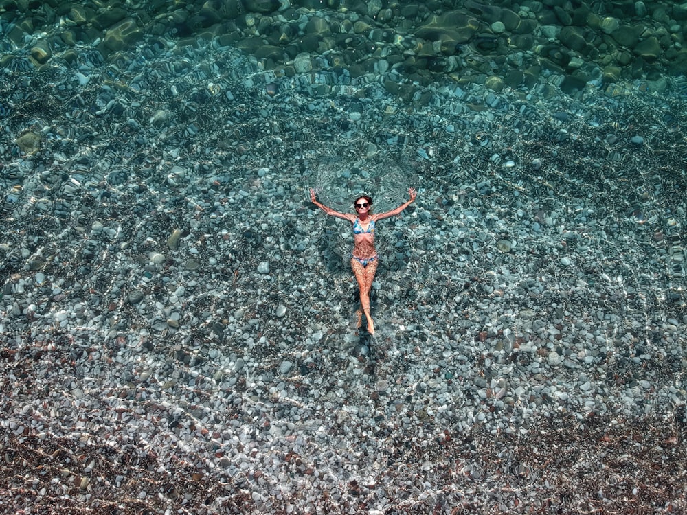 woman in red bikini swimming on water during daytime