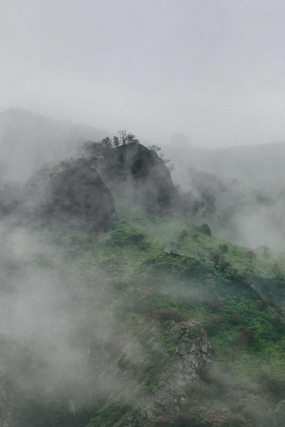 Grüner Berg mit Nebel bedeckt