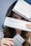 A person is holding three boxes, with focus on the box labeled 'Restylane'. The upper box partially covers their face, revealing only the eyes. The middle box prominently displays the 'Restylane' branding, and the bottom box has text in another language.