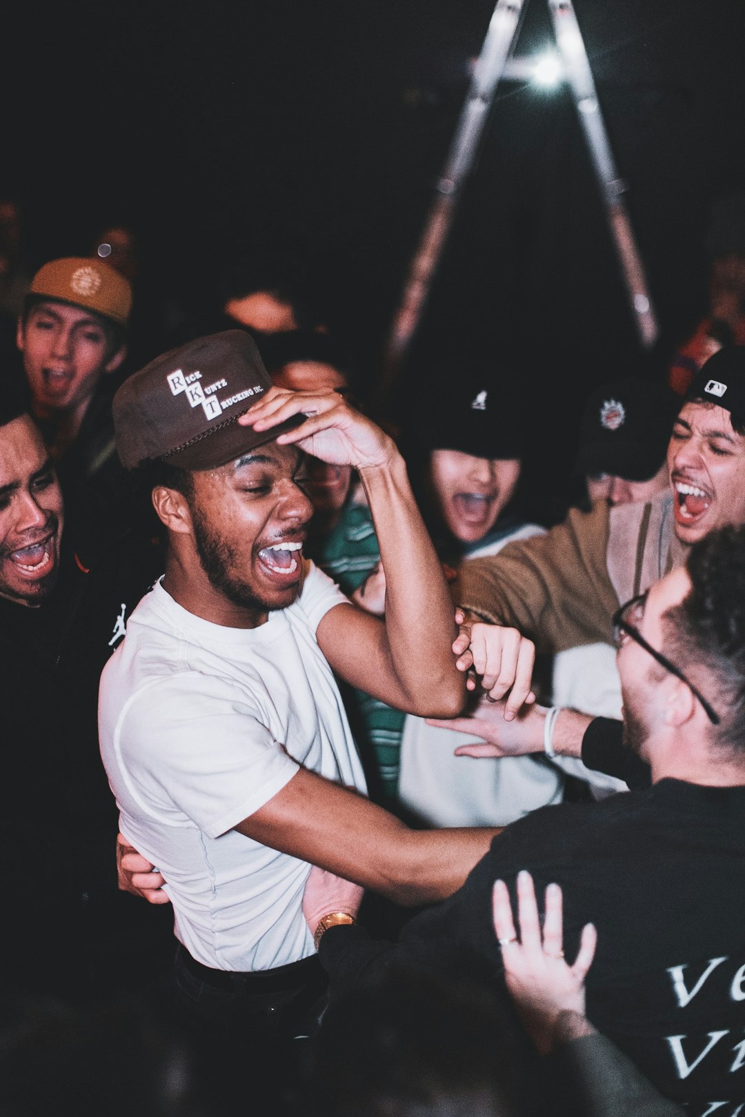 man in white crew neck t-shirt wearing black cap