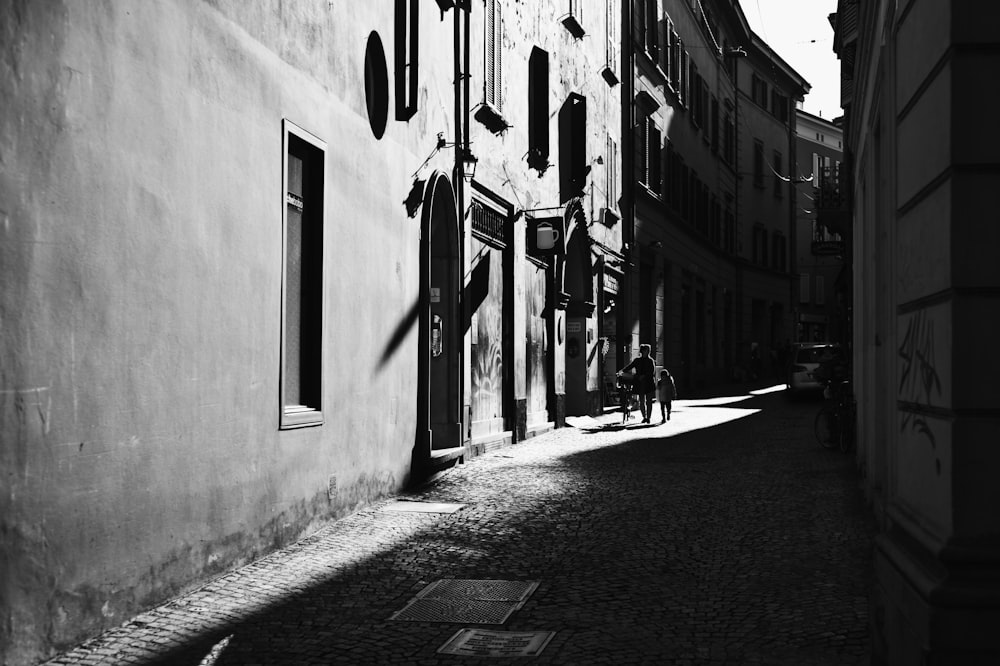 grayscale photo of people walking on sidewalk