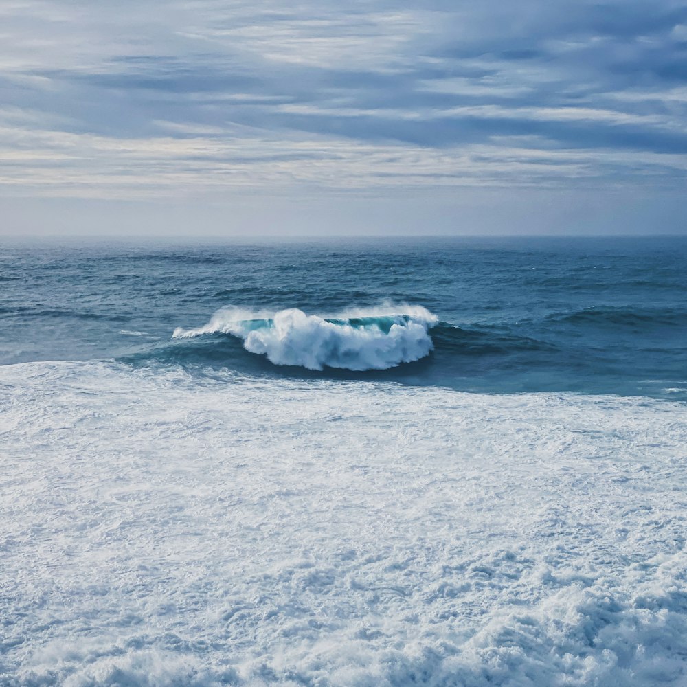 white sea waves on white sand during daytime