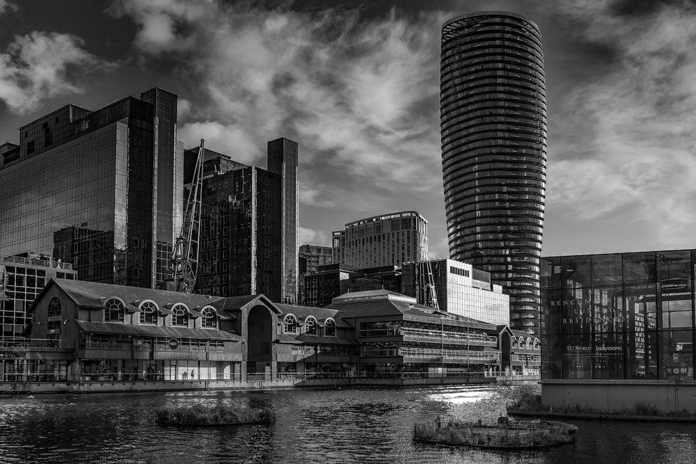 grayscale photo of city buildings near body of water