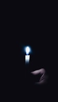 Close-up of hands gently holding a glowing candle, symbolizing inner light.