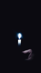 Close-up of hands gently holding a candle lit in remembrance.