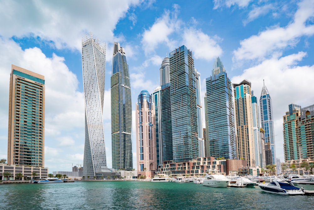 Barco blanco y azul en el mar cerca de los edificios de la ciudad durante el día