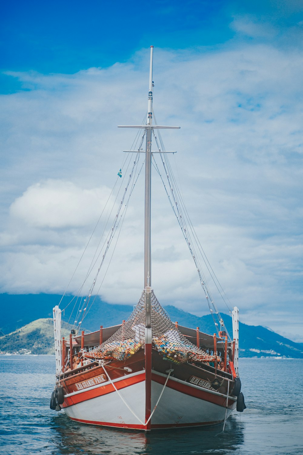 brown wooden boat on sea under white clouds and blue sky during daytime