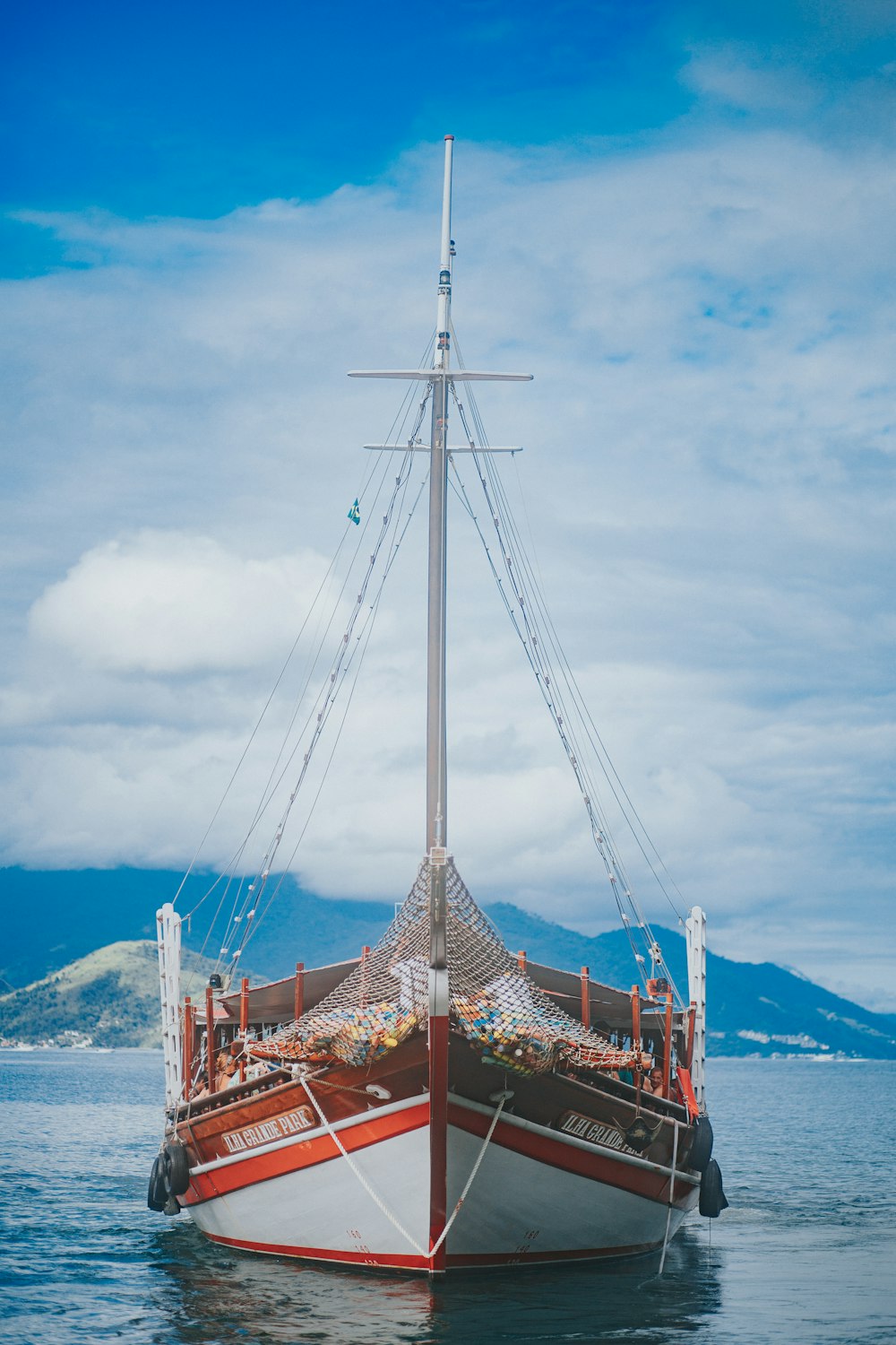 bateau en bois brun sur la mer sous les nuages blancs et le ciel bleu pendant la journée