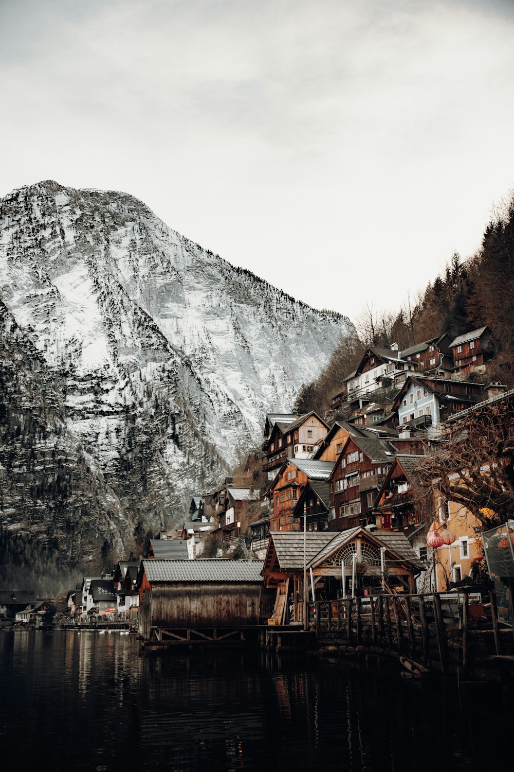 brown and white concrete houses near mountain under white sky during daytime