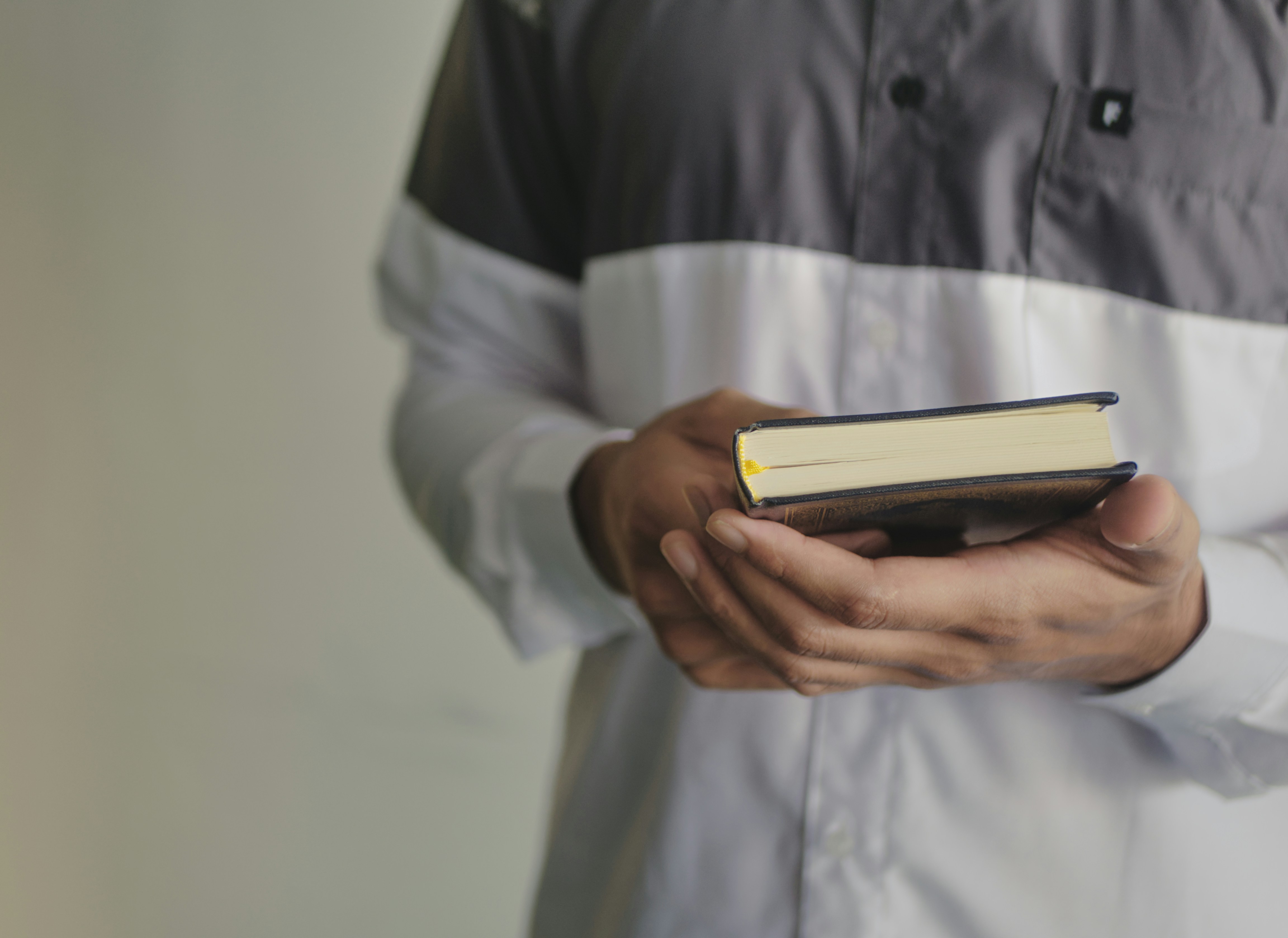 Person im weißen Hemd mit weißem und schwarzem Buch