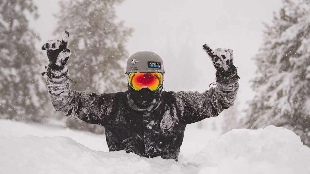 person in black jacket and red helmet on snow covered ground during daytime