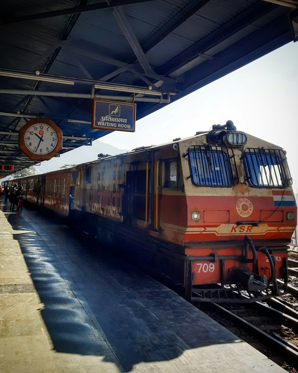 Train orange sur rail pendant la journée