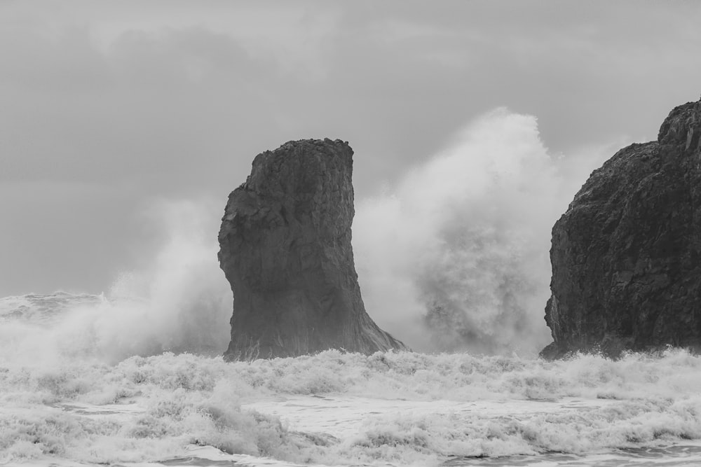 grayscale photo of rock formation on white snow