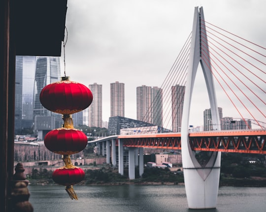 red and yellow round ball on white concrete bridge during daytime in Chongqing China