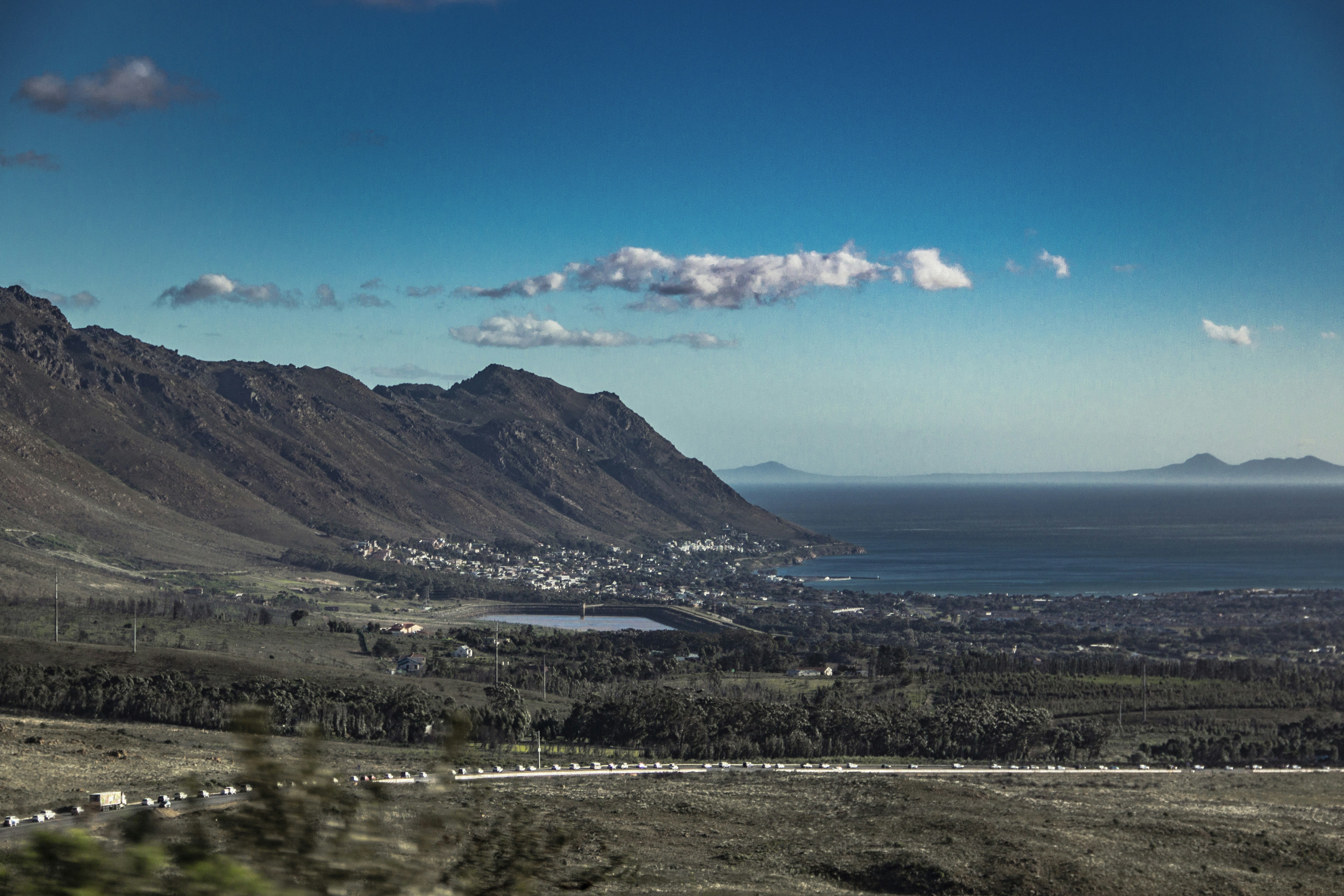 green mountains near body of water under blue sky during daytime