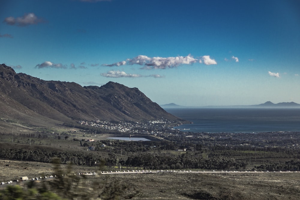 green mountains near body of water under blue sky during daytime