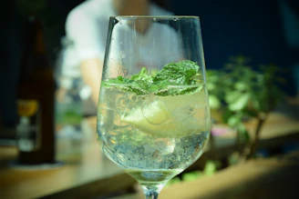 Close-up of a refreshing mojito with mint leaves and lime on a sleek black table.