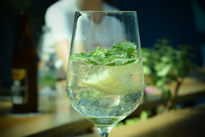 Close-up of a refreshing mojito with mint leaves and lime on a sleek black table.