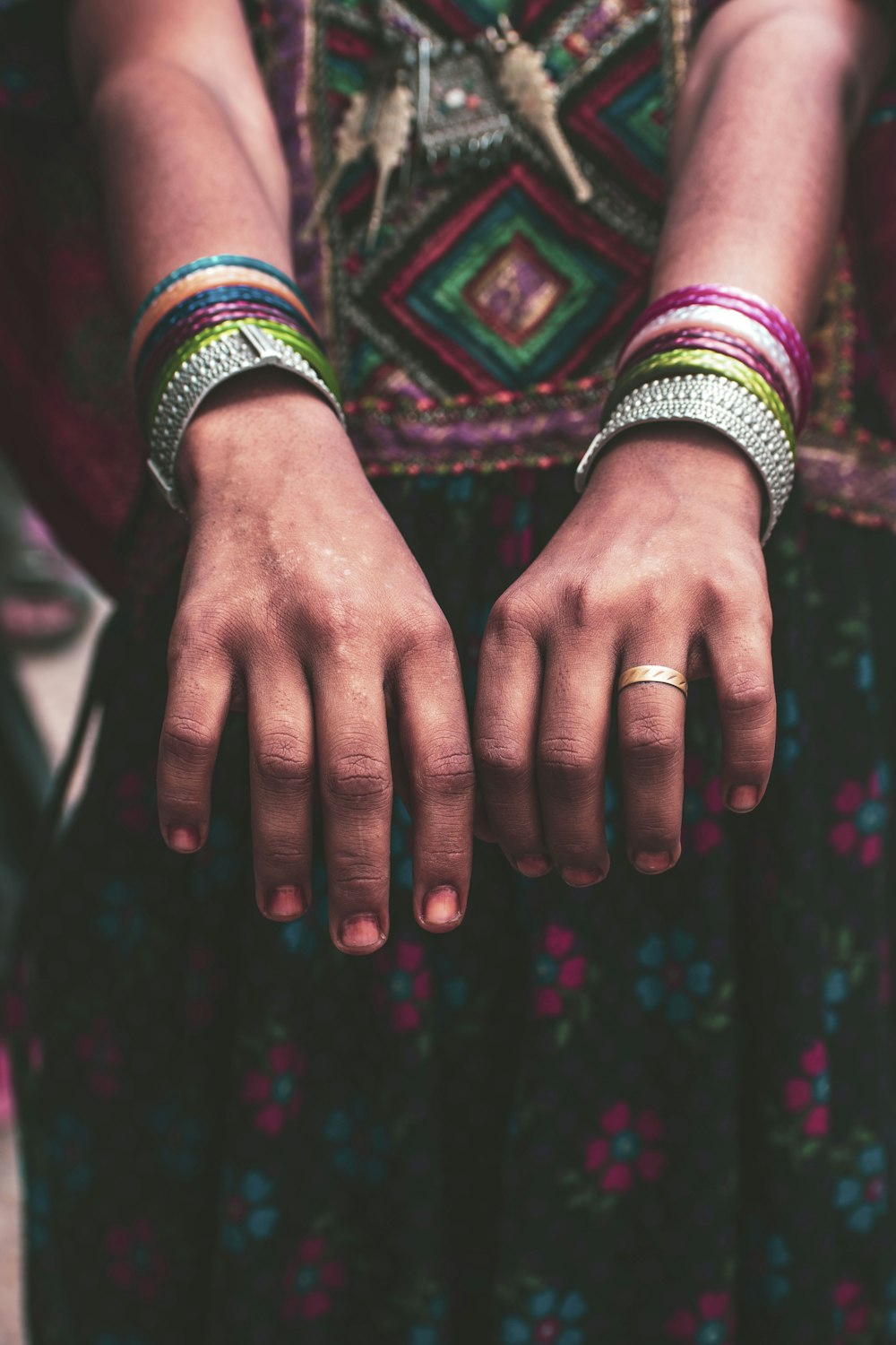 a close up of a person's hands wearing bracelets