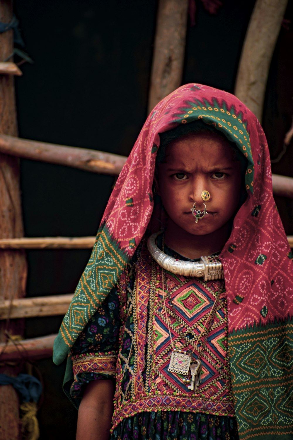 a young girl with a nose piercing wearing a colorful dress