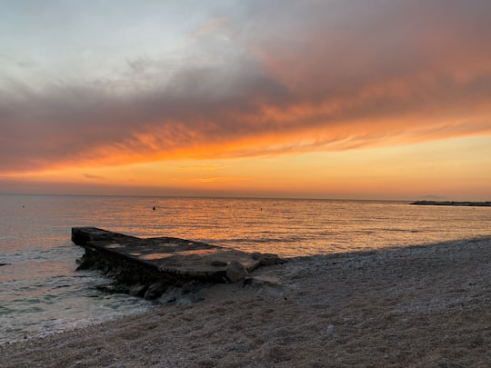 brown rock formation on sea shore during sunset in Novalja Croatia