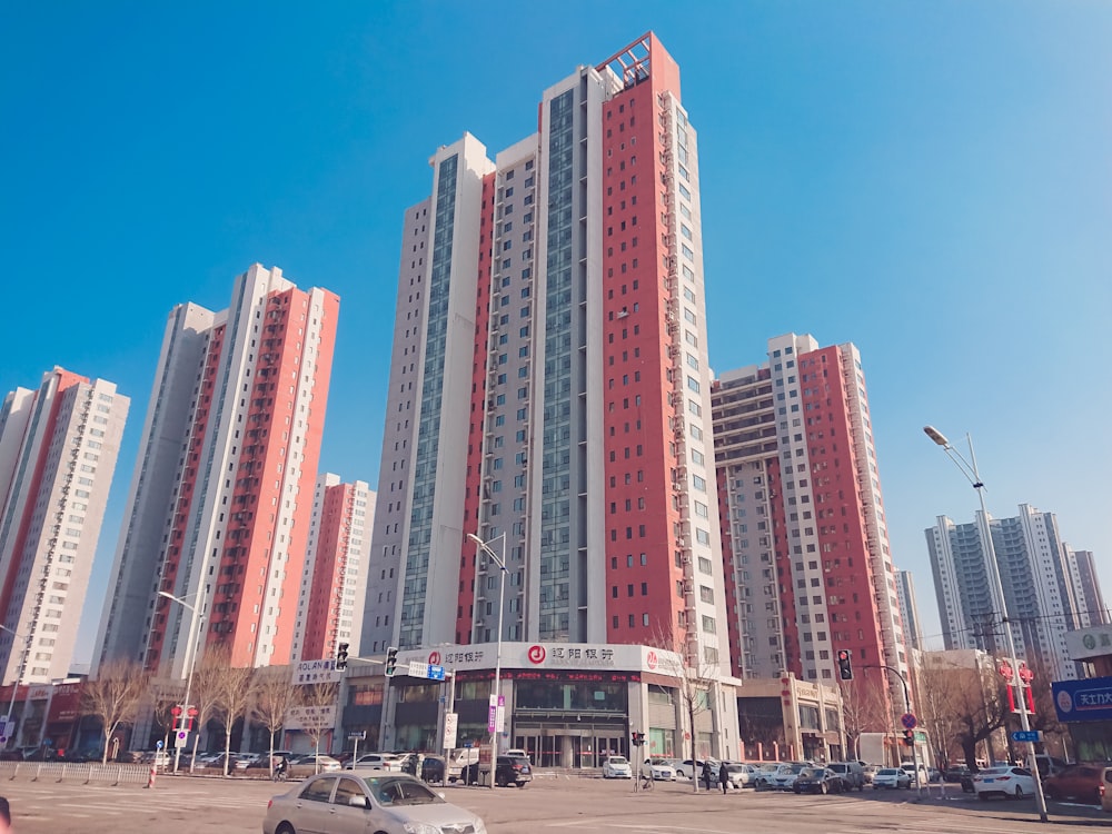 cars parked on parking lot near high rise buildings during daytime