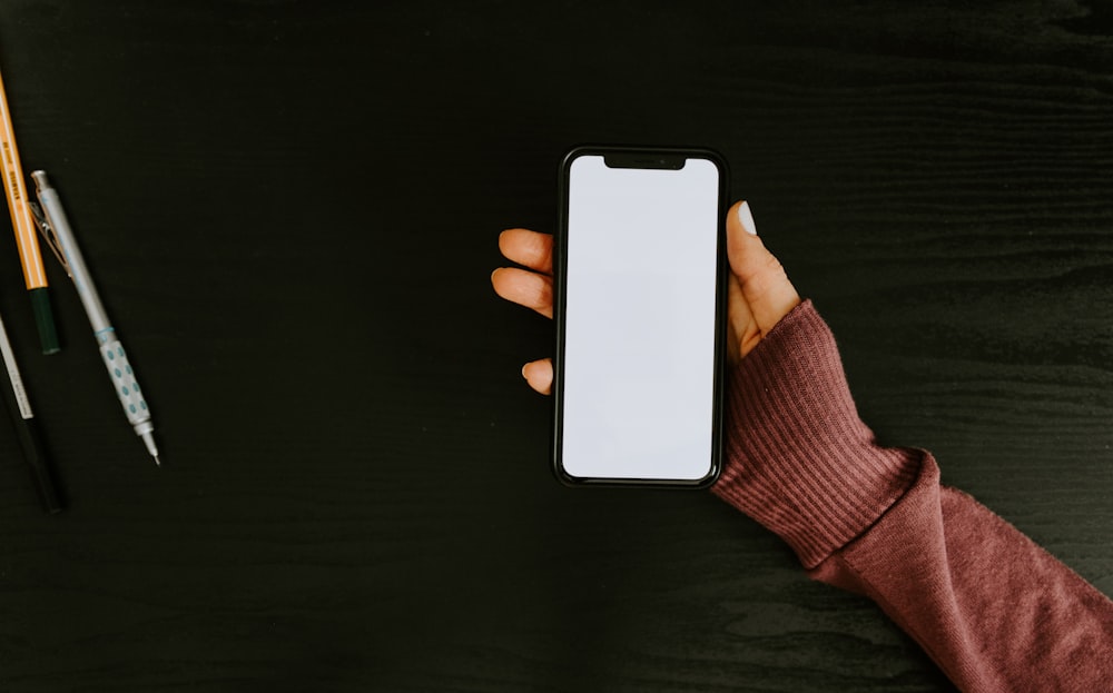 person holding white iphone 5 c