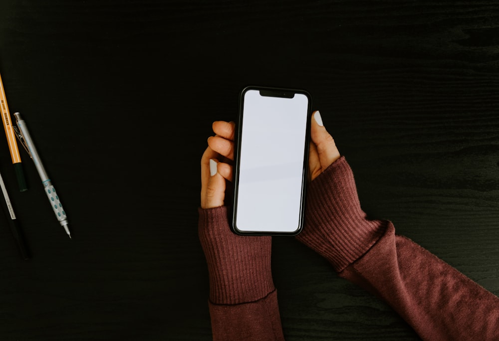 person holding white iphone 5 c