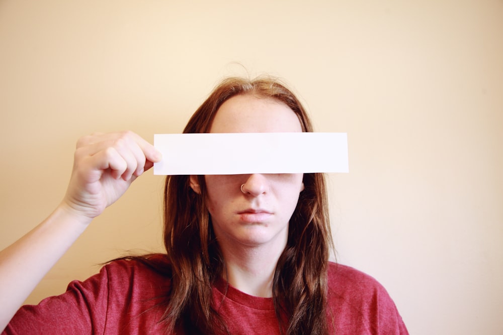 woman in red long sleeve shirt holding white paper