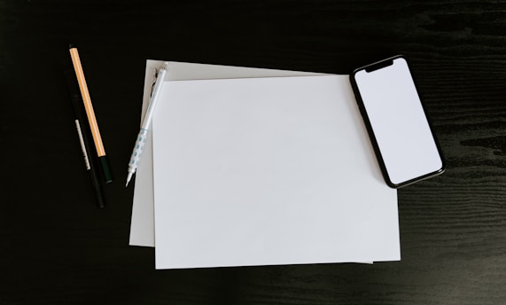 white printer paper on black table