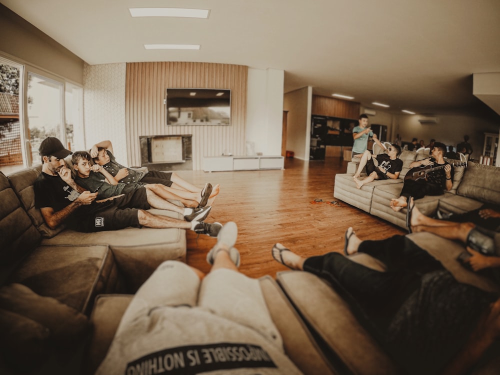 man in black jacket sitting on brown couch