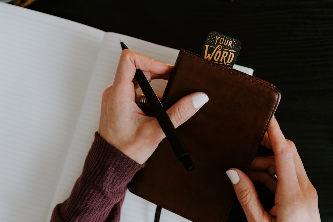 person holding brown leather book